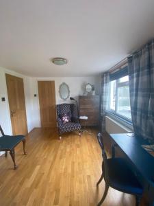 ein Wohnzimmer mit einem Stuhl und einem Fenster in der Unterkunft Zen Cottage, Cheltenham in Cheltenham