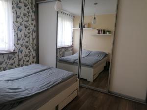 a bedroom with two beds and a mirror at Books Apartments- blisko morza in Gdańsk