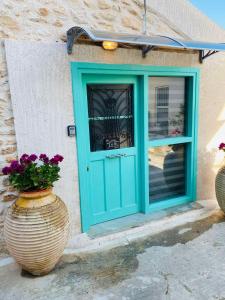 a blue door and a vase with flowers in front at Old winery in Spata