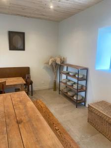 Zimmer mit einem Tisch und einem Regal mit Geschirr in der Unterkunft Gîte Un ange passe en Périgord in Le Buisson de Cadouin