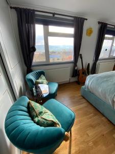 a bedroom with a bed and a couch and a chair at Zen Cottage, Cheltenham in Cheltenham