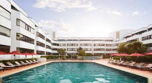 a swimming pool in front of a building at Amari Don Muang Airport Bangkok in Bangkok