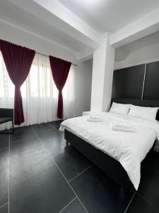 a bedroom with a large bed with red curtains at Cozy Aparthotel - Central City Suceava in Suceava