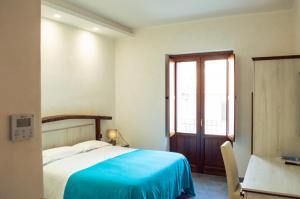 1 dormitorio con 1 cama con manta azul en Palazzo Iaquinta - Luxury Rooms & Wellness en Cicerale