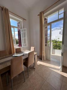 a dining room with a table and chairs and a window at Tinos Central Perfection in Tinos