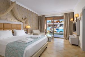 a bedroom with a bed and a living room at La Marquise Luxury Resort Complex in Faliraki