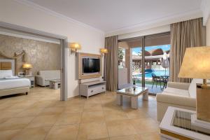 a living room with a bed and a tv and a couch at La Marquise Luxury Resort Complex in Faliraki