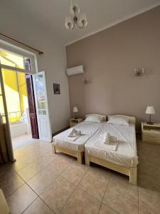 a bedroom with two beds and a large window at Tinos Central Perfection in Tinos