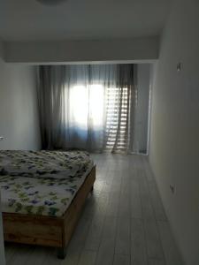 - une chambre avec un lit et une fenêtre avec des rideaux dans l'établissement Casa Olanescu Vâlcea, à Râmnicu Vâlcea