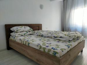 an unmade bed with a wooden frame in a bedroom at Casa Olanescu Vâlcea in Râmnicu Vâlcea