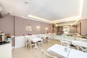 a restaurant with white tables and chairs and a counter at Mr. Bird Hotel in Istanbul
