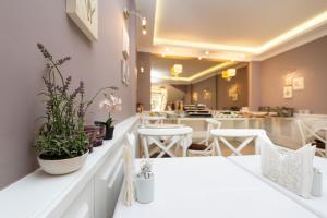 a restaurant with white tables and chairs and plants at Mr. Bird Hotel in Istanbul