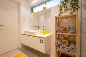 uma casa de banho com lavatório, espelho e toalhas em Moliceiros Aveiro em Aveiro