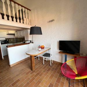 ein Wohnzimmer mit einem Tisch und einer Küche in der Unterkunft Spacieux studio vue panoramique in Propriano