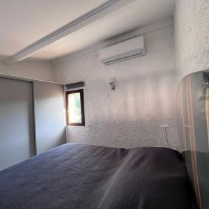 ein Schlafzimmer mit einem Bett in einem Zimmer mit einem Fenster in der Unterkunft Spacieux studio vue panoramique in Propriano