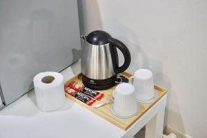 a coffee pot on a wooden tray with toilet paper at Area15 Hotel & Apartment 