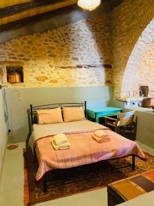 a bedroom with a bed in a room with a table at Old winery in Spata