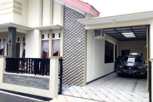samochód zaparkowany w garażu obok domu w obiekcie Aprilia Homestay Magelang w mieście Magelang