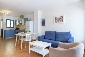 a living room with a blue couch and a table at Pleamar in Famara