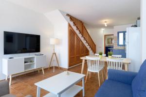 a living room with a couch and a tv at Pleamar in Famara
