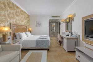 una camera d'albergo con letto e TV di La Marquise Luxury Resort Complex a Faliraki