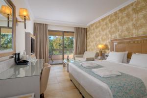 ファリラキにあるラ マルキーズ ラグジュアリー リゾート コンプレックスのベッドとリビングルームが備わるホテルルームです。
