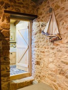 Cette chambre dispose d'une porte et d'une fenêtre dans un mur en pierre. dans l'établissement Old winery, à Spáta