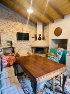 a living room with a wooden table and a fireplace at Old winery in Spata