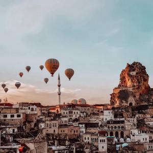 a group of hot air balloons flying over a city at Vita Cave Suites in Urgup