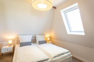 twee bedden in een kleine kamer met een raam bij Urlaub auf dem Lande - Ferien-Apartment Nord-Ost in Gremersdorf