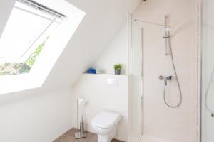 uma casa de banho branca com um chuveiro e um WC. em Urlaub auf dem Lande - Ferien-Apartment Nord-Ost em Gremersdorf