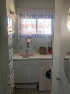 uma casa de banho com um lavatório e uma máquina de lavar roupa em Appartement bord de mer em La Tranche-sur-Mer