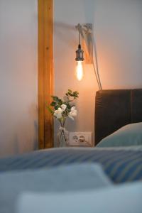 una camera da letto con una lampada e un vaso di fiori di Apartman Time out 2 a Sombor