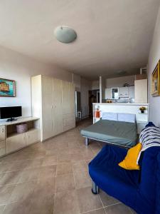 un soggiorno con un letto e una cucina di Casa Pinolo Monolocale Vista Mare a Follonica