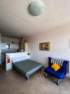 ein Schlafzimmer mit einem Bett und einem blauen Stuhl in der Unterkunft Casa Pinolo Monolocale Vista Mare in Follonica
