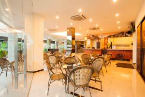 un comedor con mesas y sillas en un restaurante en LEO Express Hotel, en Kuala Lumpur