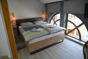 un letto in una camera con una grande finestra di Apartman Time out 2 a Sombor
