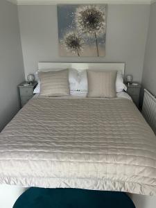 a bedroom with a large bed with white sheets and pillows at Beachglass in Lynton