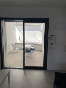 una camera con porta scorrevole in vetro con tavolo e sedie di La Torre del Porto a Riccione