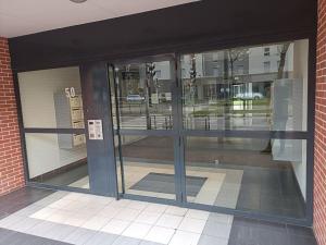 ein leerer Eingang zu einem Gebäude mit Glastüren in der Unterkunft Avenue de Caen in Rouen