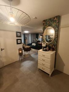 ein Wohnzimmer mit einer Kommode und einem Spiegel in der Unterkunft Avenue de Caen in Rouen