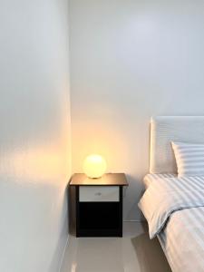 a small table with a lamp on it next to a bed at Area15 Hotel & Apartment 