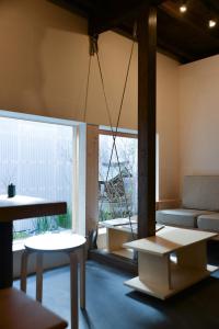 Habitación con mesas, sofá y ventana en Bokuyado Nishijin, en Kioto