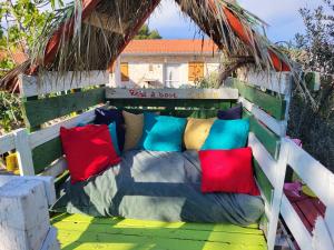 una cama con almohadas coloridas encima en Kuća za odmor Zip en Murter