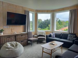 a living room with a couch and a flat screen tv at Relax in Kenmure in Dunedin