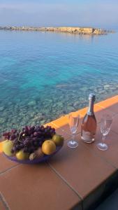 - une table avec une assiette de fruits et une bouteille de vin dans l'établissement Casa di charme Bastioni, à Gallipoli