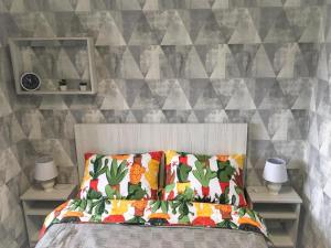 a bedroom with a bed with two lamps and a wall at Мелодия прованса в старом центре in Kharkiv