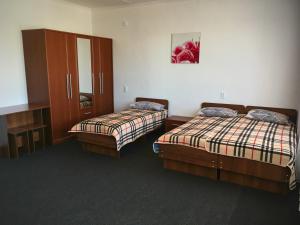 a room with two beds and a cabinet and a mirror at Гостевой дом Крылья in Cholpon-Ata