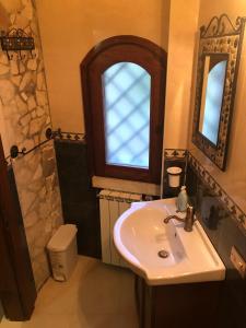 een badkamer met een wastafel en een raam bij B&B Villa Torri Petrose in Pontelatone