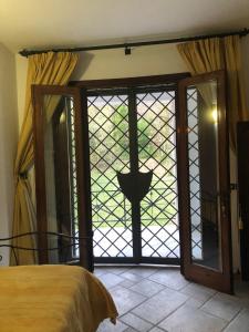 een slaapkamer met een glazen schuifdeur en uitzicht bij B&B Villa Torri Petrose in Pontelatone